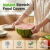 Transparent Cecurpo disposable stretch food covers protecting a bowl of fresh fruit on a kitchen counter.