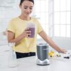 In-use shot showing the 24-ounce Nutribullet cup being twisted onto the blender base for quick smoothie prep.