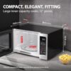 Side profile of the Toshiba 1100W microwave showing the easy-grip door handle and compact dimensions.
