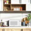 Side profile of the compact white microwave measuring 12.75 x 10 x 18 inches for small kitchen spaces.