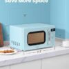 The green retro microwave oven placed in a cozy dorm room space for convenient snacking.
