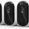 Three white Arlo Essential 2K wireless outdoor security cameras arranged for a complete home monitoring system.