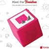 A child independently operating the pink Toniebox by placing a character on the magnetic base.