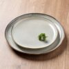 A stack of AmorArc ceramic plates and bowls demonstrating the space-saving, nestable design.