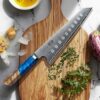Ergonomic blue resin and wood octagonal handle of the HOSHANHO Damascus Santoku knife.