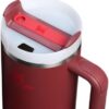 The 40 oz Stanley tumbler in cranberry placed inside a car cup holder to showcase its narrow base design.