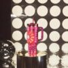 The 40 oz Stanley Barbie tumbler placed in a car cup holder to showcase its travel-friendly design.