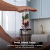 User demonstrating the push-to-blend functionality to pulse ingredients in the Nutri-Blender Plus.