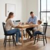 Six black Windsor dining chairs arranged around a wooden table in a bright, modern dining room setting.
