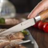 Side profile of the Kangdelun steak knife showing the ergonomic one-piece wood handle design