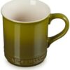 The Le Creuset stoneware mug filled with coffee, showcasing its superior heat retention for hot drinks.