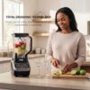 An in-use shot of the Ninja professional blender for ice crushing frozen fruit into a creamy smoothie.