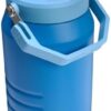 A Stanley 64 oz insulated water jug sitting on a table, showcasing its vacuum insulation capabilities.