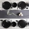 Minimalist round style black matte stoneware dinnerware set on a dining table