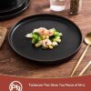 Person serving dinner on a Famiware Nebula Ridge matte black plate to show everyday usage.
