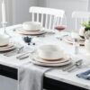 A neatly stacked set of 12 TARA stoneware dishes demonstrating the compact and stackable design