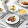 Microwave and dishwasher safe porcelain dinnerware set arranged for an elegant dining table.