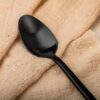 Side profile view showcasing the unique geometric cube handle of the matte black teaspoons.