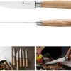 Table setting featuring the 8-piece serrated steak knife set with natural ash handles for a warm dining aesthetic.