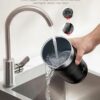 An electric milk frother operating silently on a kitchen counter to create perfect cappuccino foam.