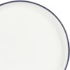 A modern dining table arrangement featuring the white and navy Gibson Home porcelain dinnerware set