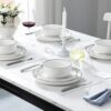 A set of four dinner plates and four salad plates from the 12 piece porcelain dinnerware set on a dining table.