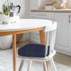 Group of six Iristykilin waterproof dining chair cushions styled on wooden kitchen furniture.