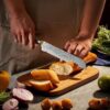 A selection of the 16-piece Damascus knife set laid out on a kitchen counter for meal prep.